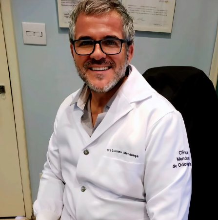 Dr. Luciano Terreri Mendonça sorrindo, de jaleco, na Clínica Mendonça